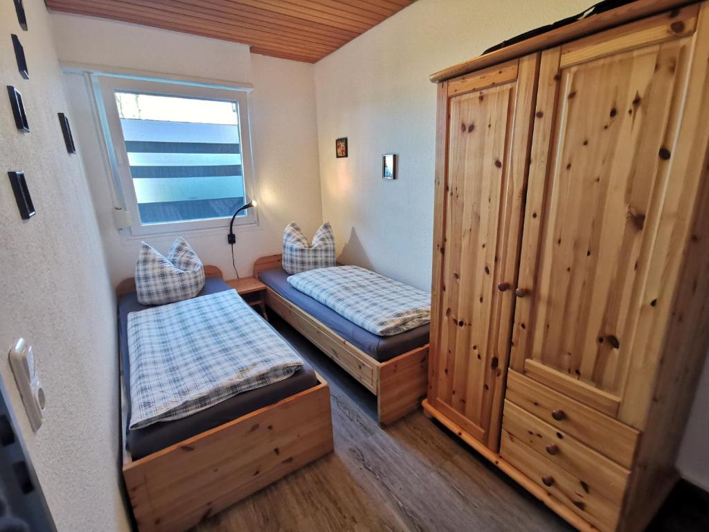 a small room with two beds and a window at Nordseegras in Horumersiel