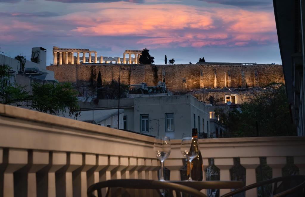 アテネにあるAcropolis Apartment with a unique viewのワイングラスとテーブルからアクロポリスの景色を望めます。