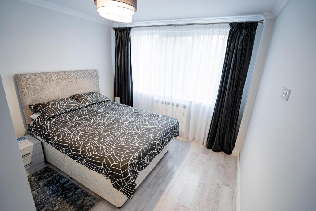 a bedroom with a bed and a window at Gabi Apartament in Suceava