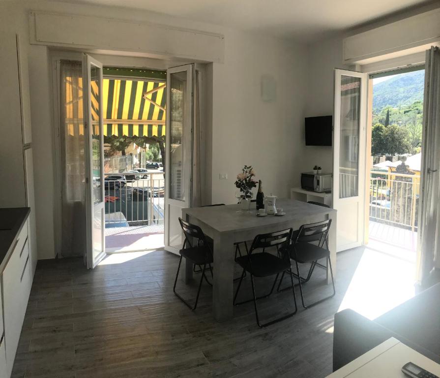 a kitchen with a table and chairs and a balcony at HOST IN LEVANTO - Maestrale con biciclette in Levanto