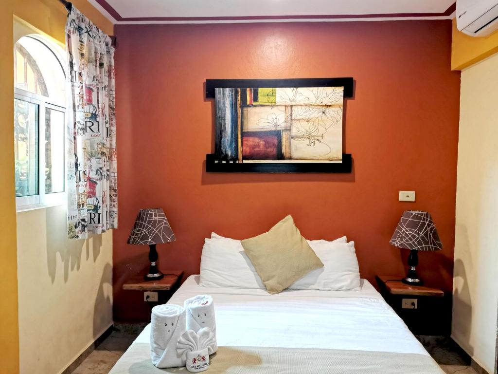 1 dormitorio con 1 cama con pared de color naranja en Hotel Casa Mallorca, en Cancún