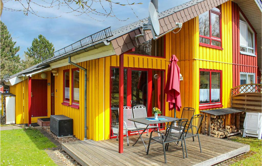 een geel huis met een tafel en stoelen op een terras bij 3 Bedroom Awesome Home In Extertal in Extertal