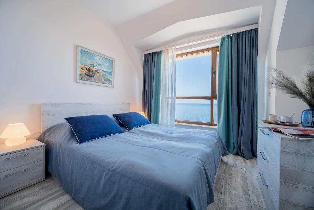 a bedroom with a blue bed and a window at Dreams in La Mer in Golden Sands