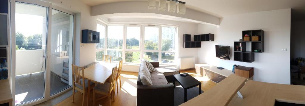 a living room with a table and a large window at ParkView Apartment in Gdańsk