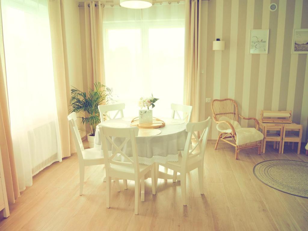 comedor con mesa blanca y sillas en SlowHouse - dom z własną sauną!, en Kopalino