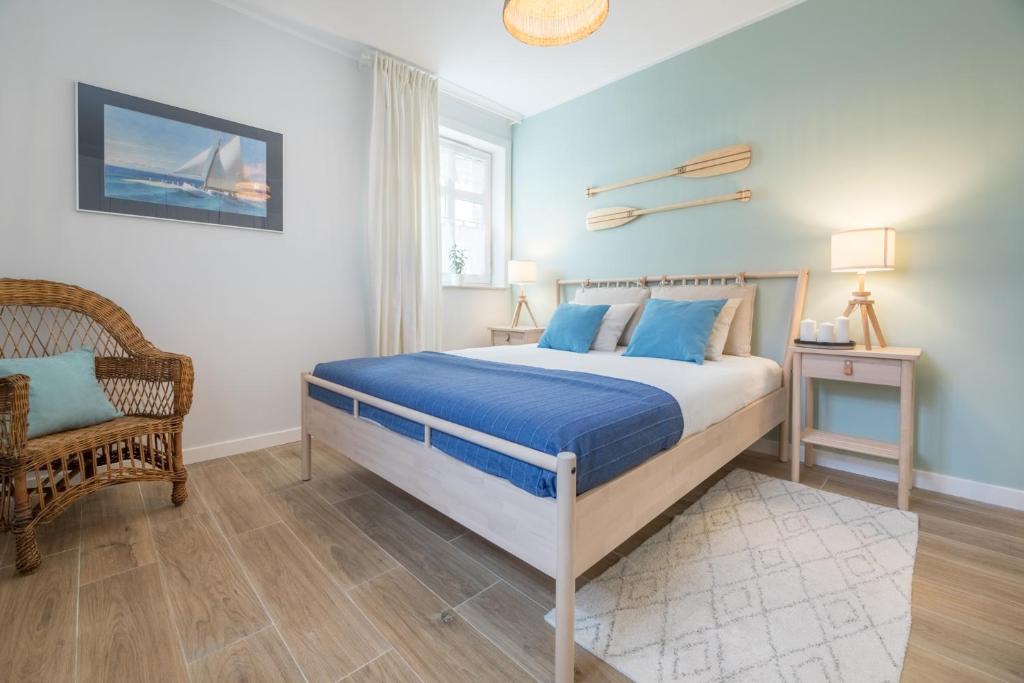 1 dormitorio con cama con sábanas azules y silla en Stay in Ustka, en Ustka