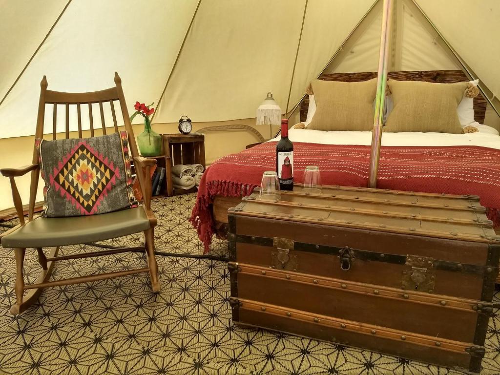 a bedroom with a bed and a chair and a suitcase at Romantic Safari tent in Tortosa