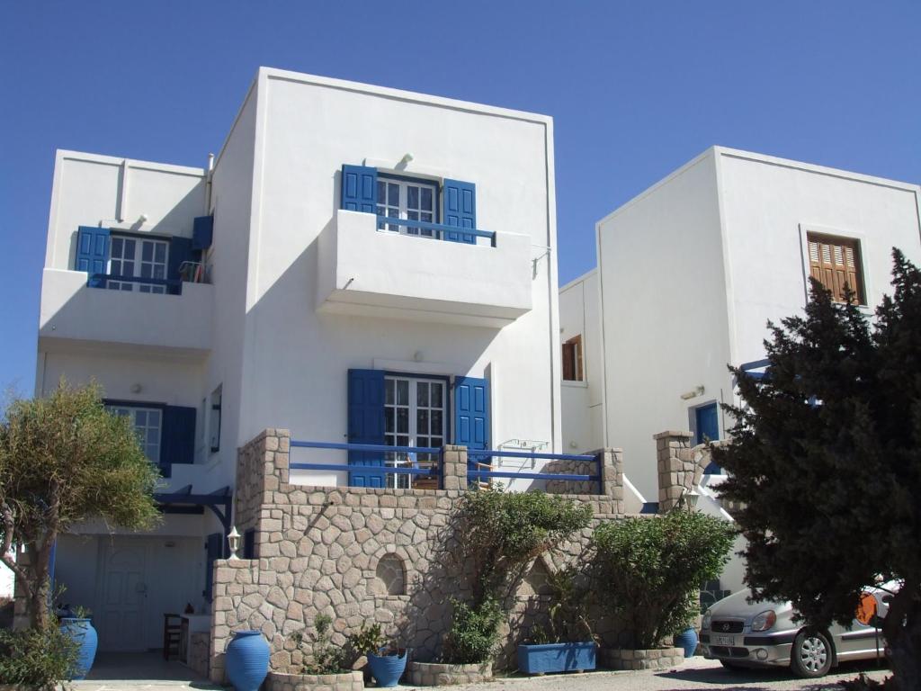 a white house with blue doors and windows at Captain Stavros in Pollonia