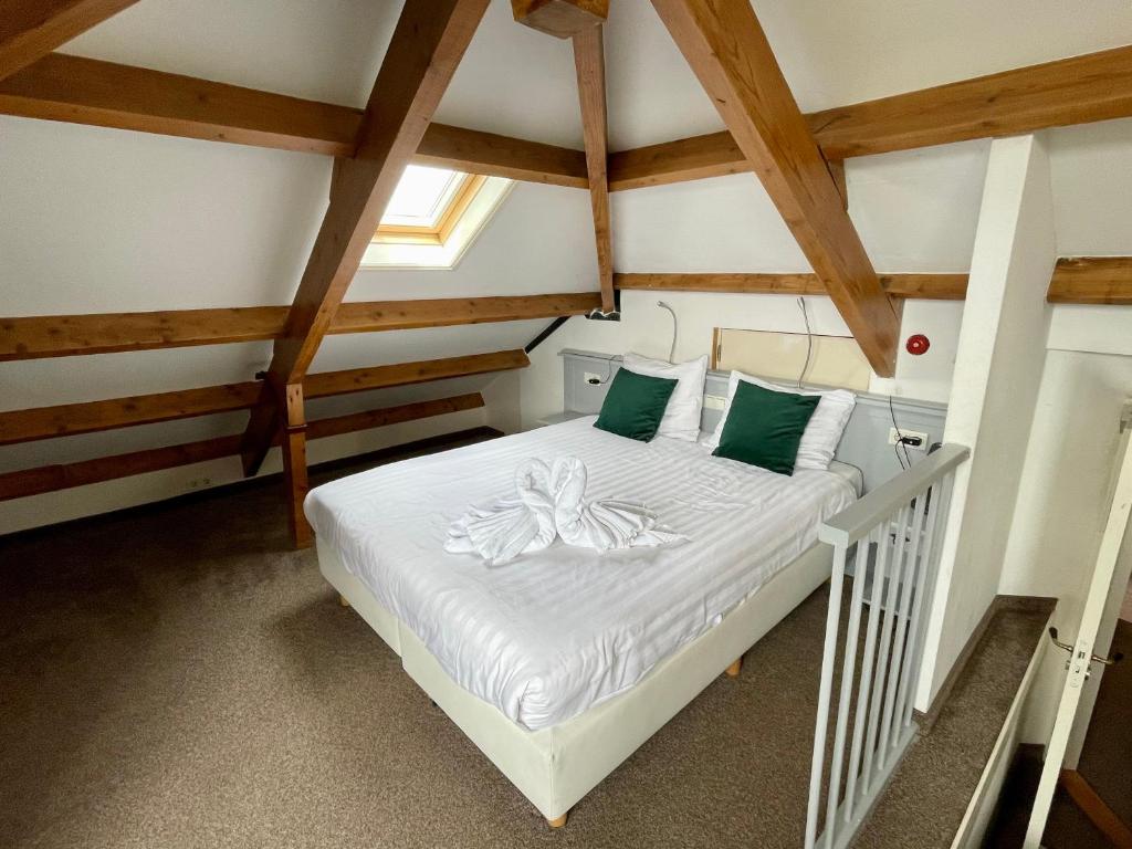 een slaapkamer met een bed op zolder bij Havenhotel At Sea Texel in Oudeschild