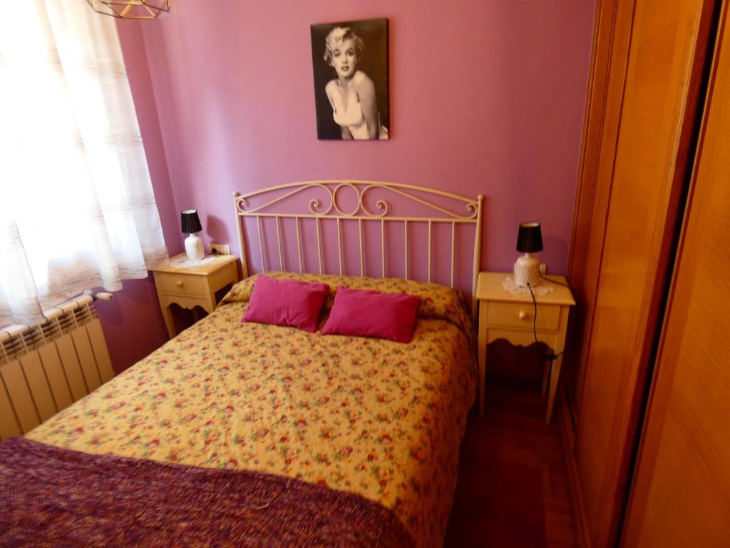 a bedroom with a bed with two pink pillows at Mi humilde morada in Redondela