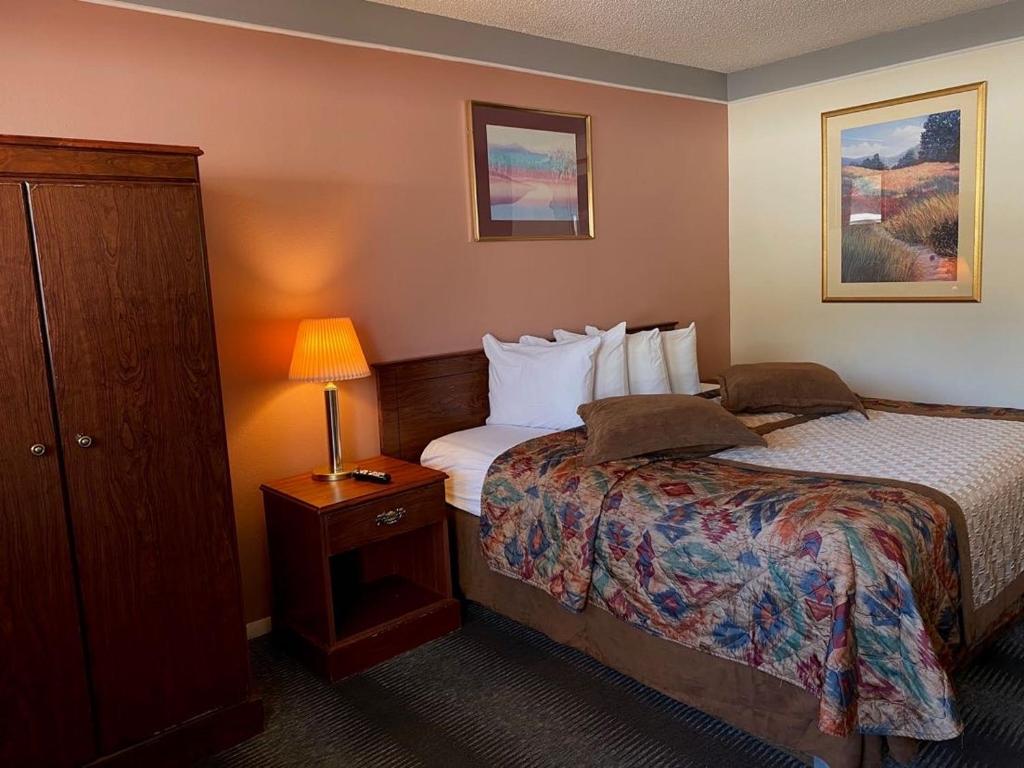 a hotel room with two beds and a lamp at Value Lodge Inn in Delta