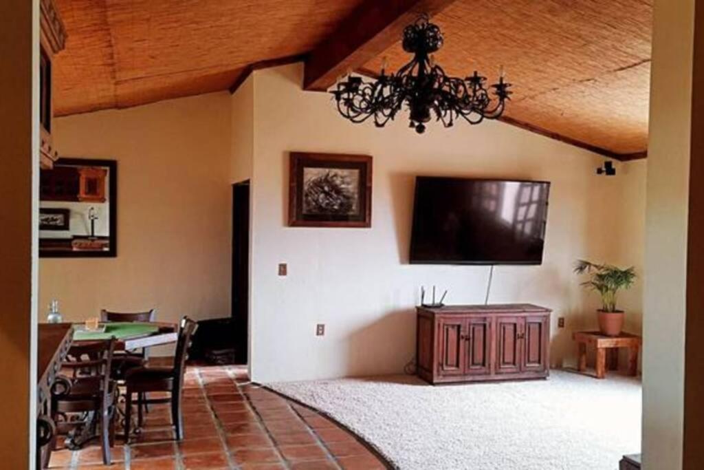 een woonkamer met een tafel en een flatscreen-tv bij Large apartament near the beach in Rosarito