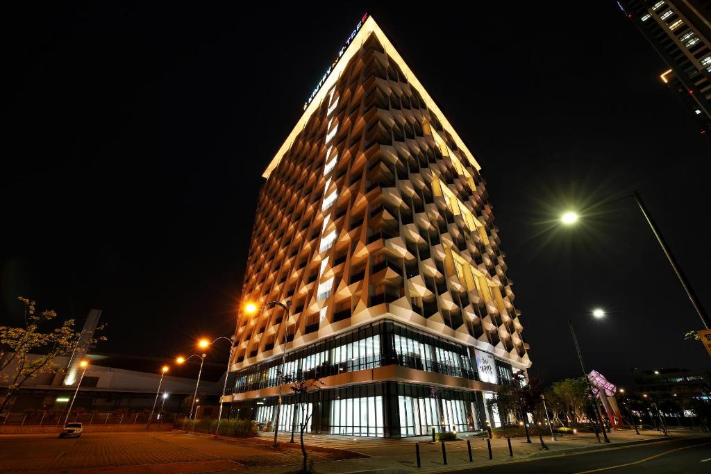 um edifício alto à noite com em Kintex by K-tree em Goyang