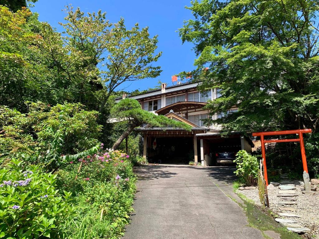 草津的住宿－桐島屋旅館，车道前有橙色门的建筑