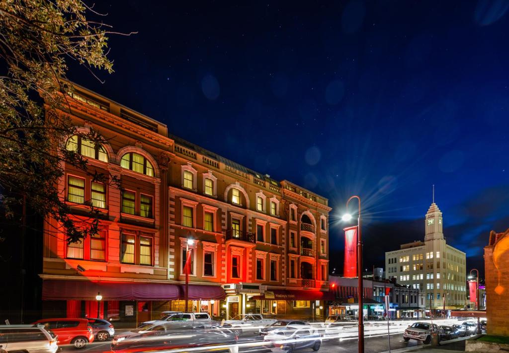 a building with red lights on a city street at night at Hadley's Orient Hotel in Hobart