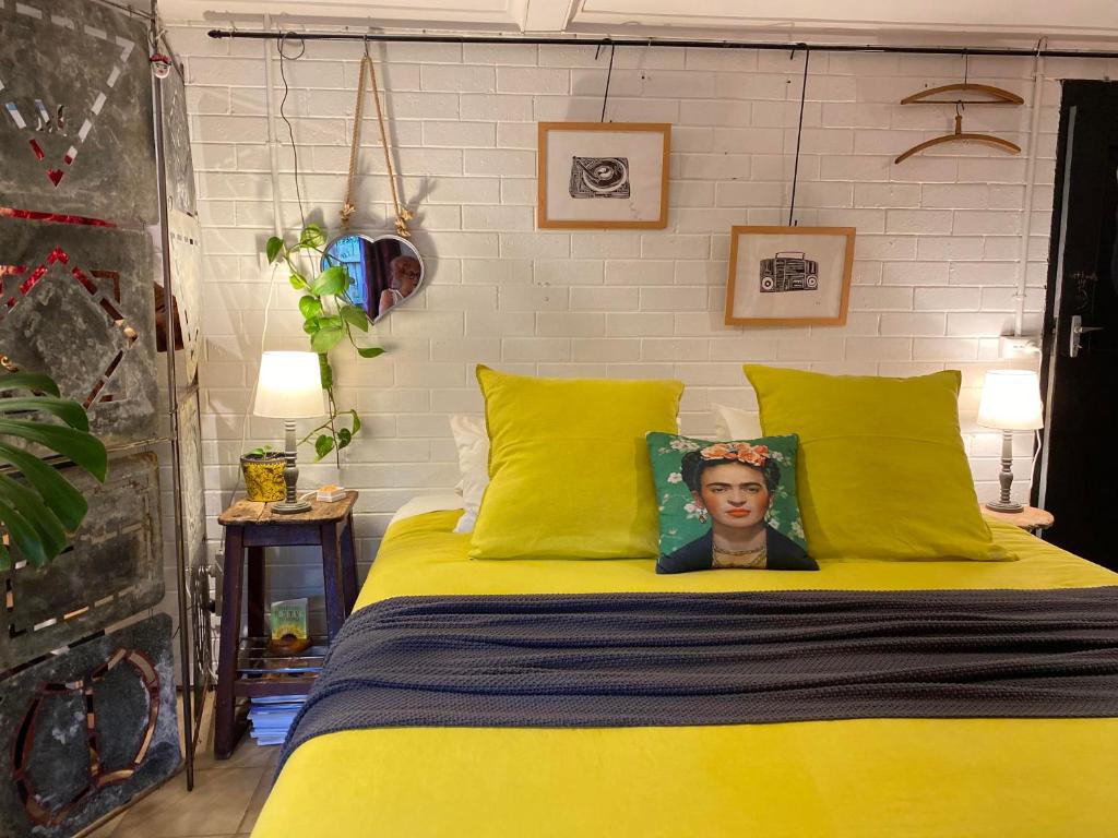 uma cama amarela com uma foto de um homem nela em The Studio em Rye