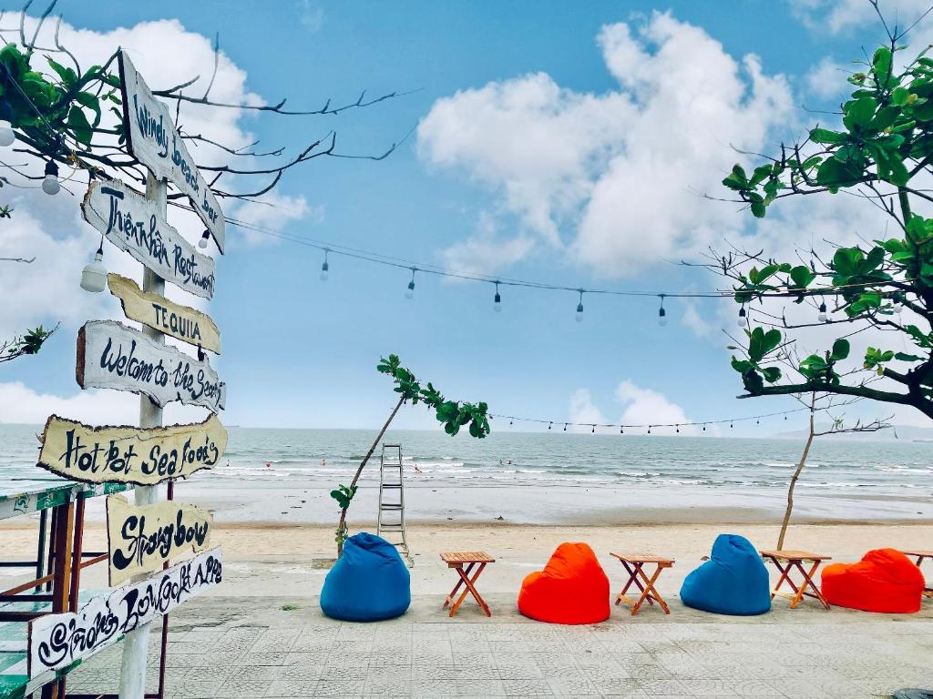 a beach with chairs and signs and the ocean at Thien Nhan Hotel in Cửa Lò