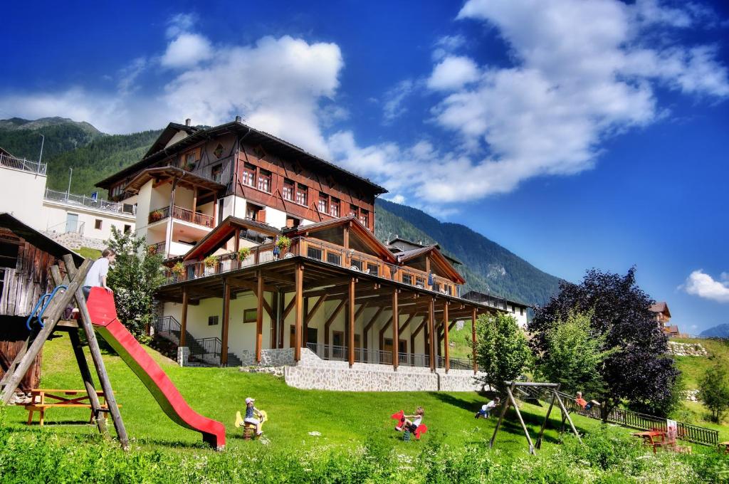 un gran edificio con un parque infantil delante de él en Albergo Miramonti, en Rabbi