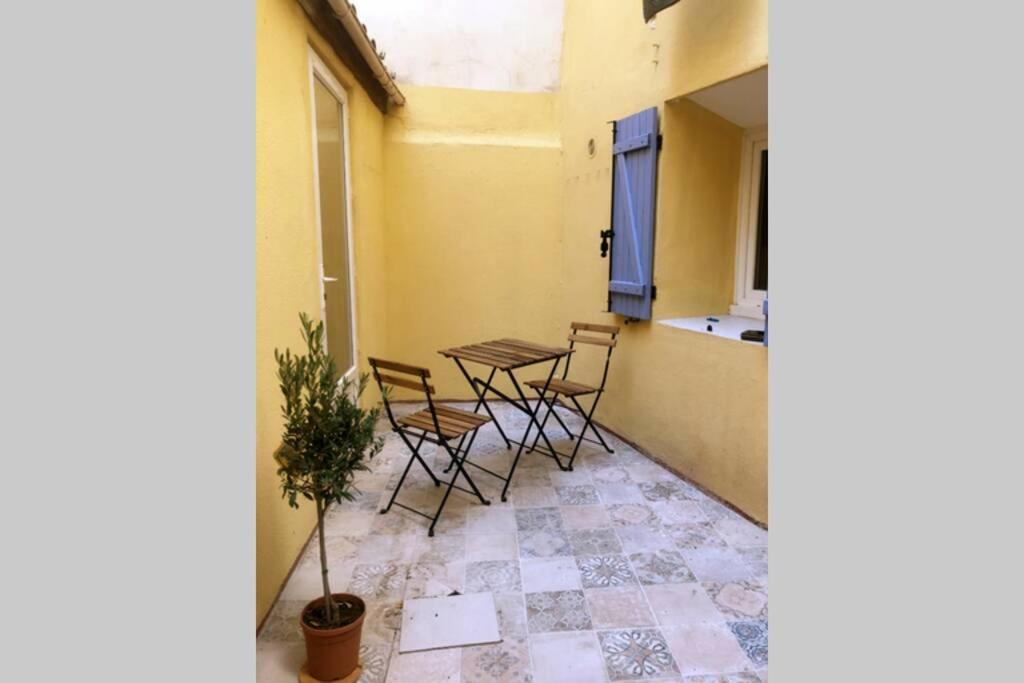 Cette chambre dispose d'un balcon avec des chaises et une table. dans l'établissement Charmante Escale au Cœur du Panier près Vieux Port, à Marseille