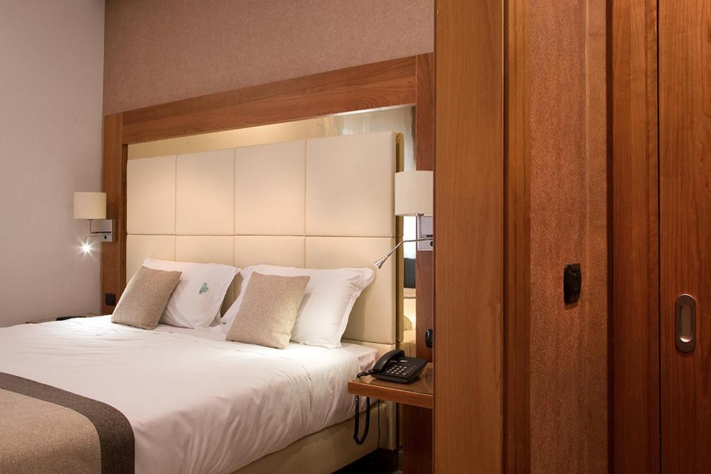 una camera d'albergo con letto e telefono di American Hotel a Pozzuoli