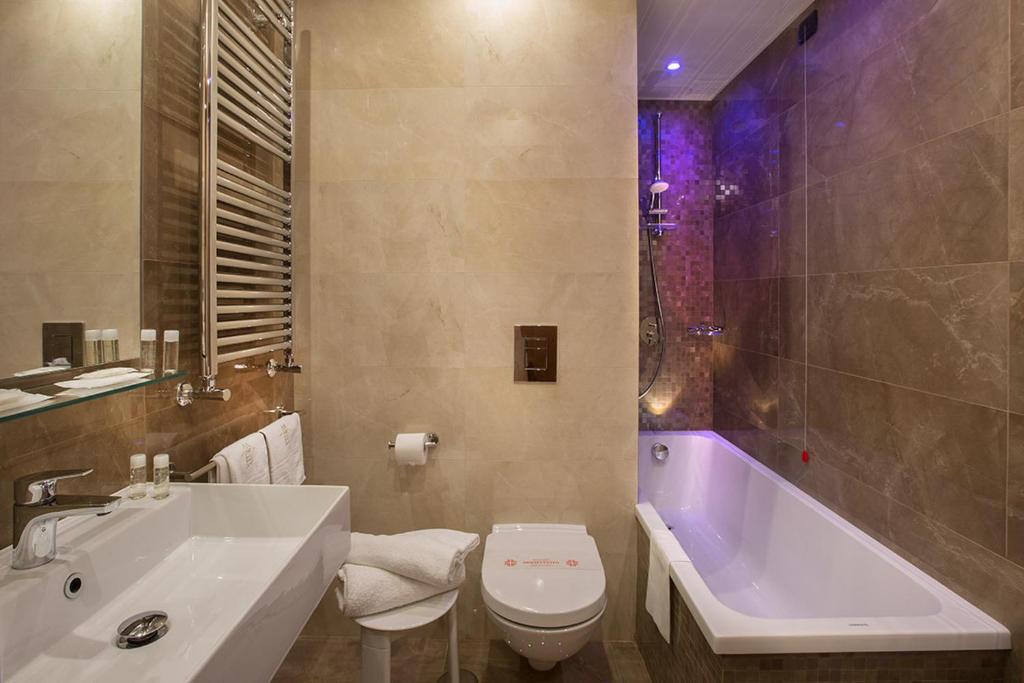 łazienka z wanną, toaletą i umywalką w obiekcie American Hotel w mieście Pozzuoli