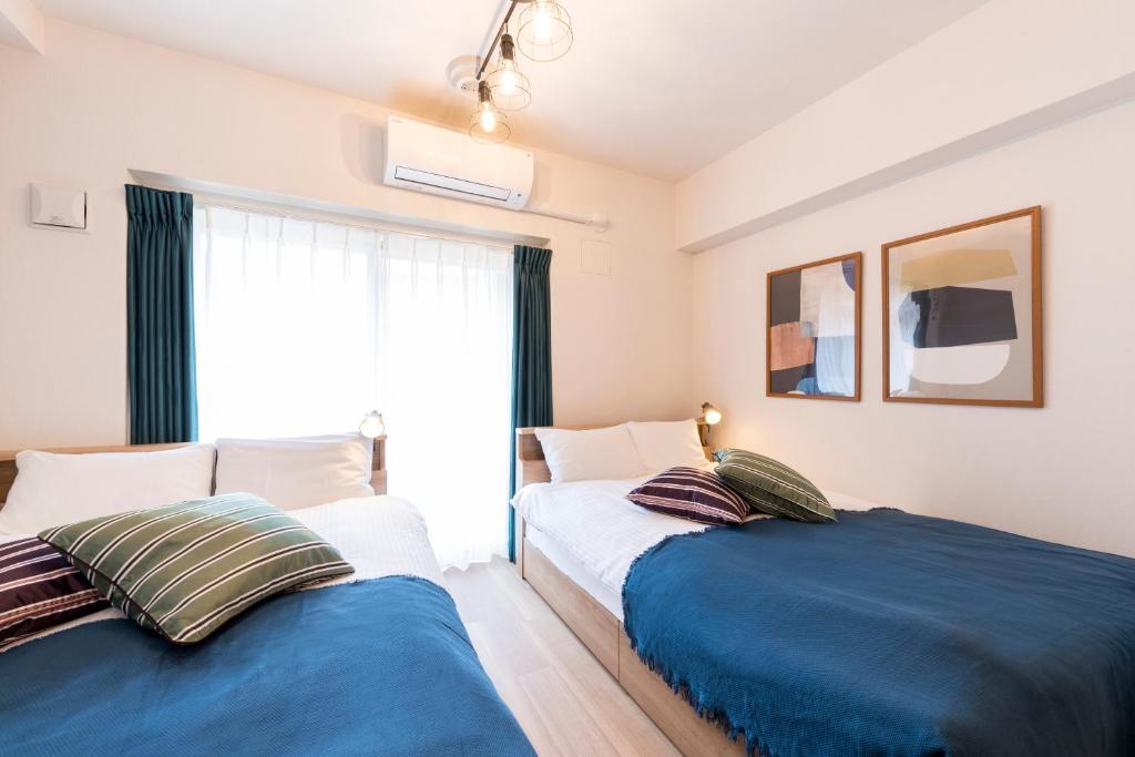 zwei nebeneinander stehende Betten in einem Schlafzimmer in der Unterkunft Hotel Ritza HAKATA in Fukuoka