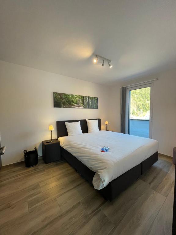 a bedroom with a large bed with white sheets at Penthouse Lebierre in Malmedy