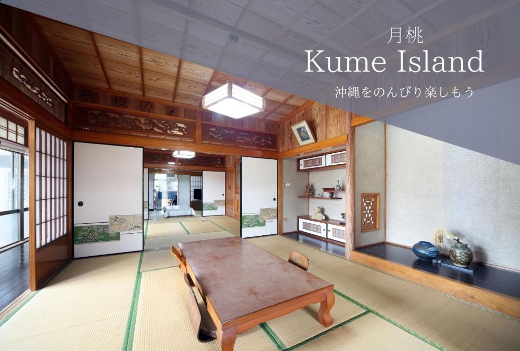 pokój z drewnianym stołem w budynku w obiekcie Kumi no Yado Gettou 2 w Kumejimie