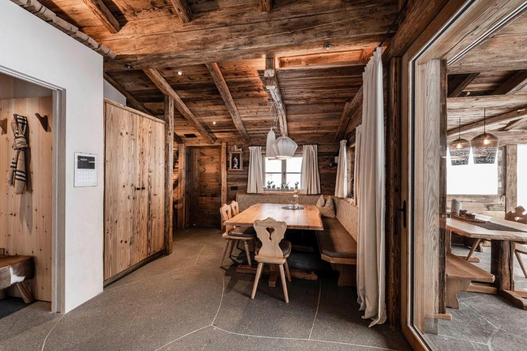 een eetkamer met een houten tafel en stoelen bij La Mendola Apartment in Mendola