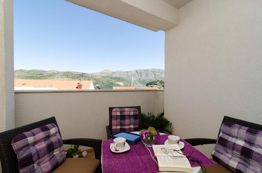 una mesa con un mantel púrpura en el balcón en Apartments Ira, en Dubrovnik