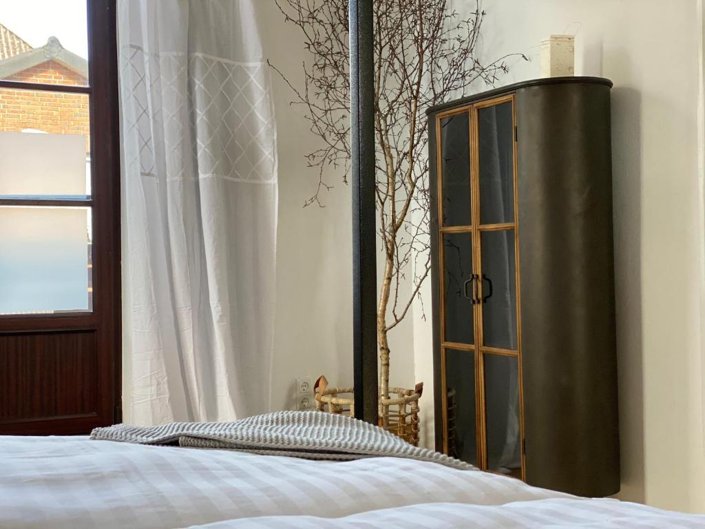 1 dormitorio con 1 cama, armario y ventana en Smukkegård - historisch Wohnen im modernen Ambiente en Tönning