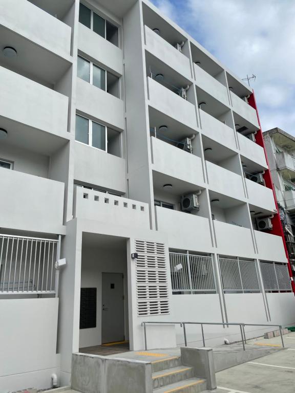 a white apartment building with a parking lot at HOTELグランシャインYAIMA in Ishigaki Island
