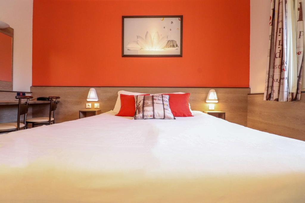 a bedroom with a large bed with red walls at ACE Hôtel Travel Athée sur Cher in Athée-sur-Cher