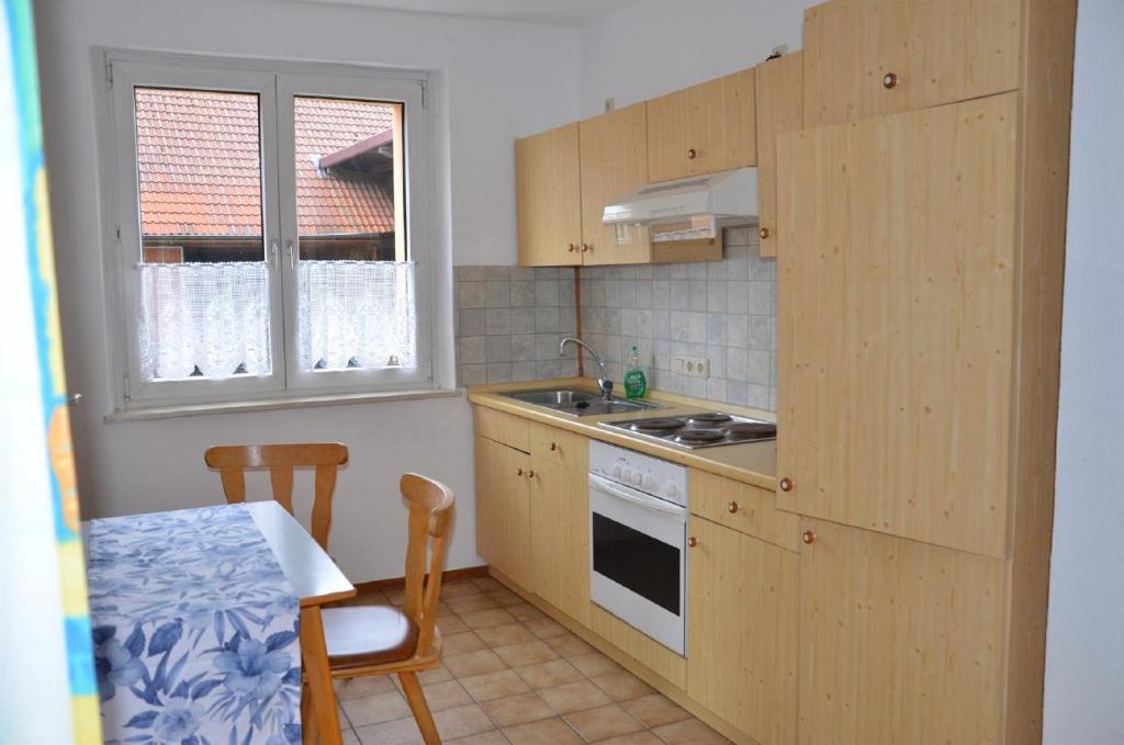 cocina con armarios de madera, mesa, mesa y sillas en Appartement Rhönzimmer, en Findlos