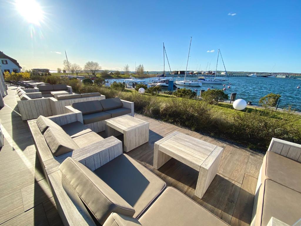 eine Reihe von Bänken auf einer Terrasse in der Nähe des Wassers in der Unterkunft mönchgut living & spa in Gager