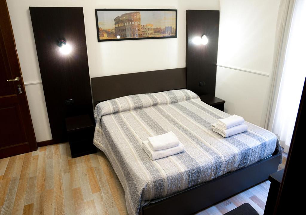 1 dormitorio con 1 cama con 2 toallas en GH Colosseum, en Roma