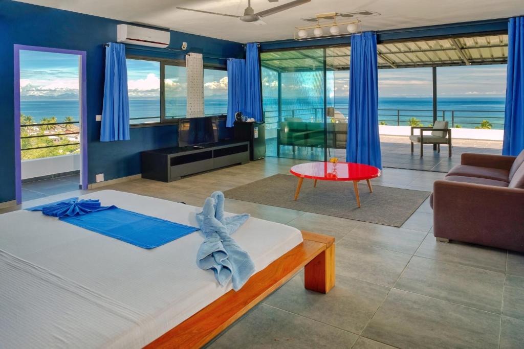 een slaapkamer met een bed en uitzicht op de oceaan bij Hôtel Villa Les Orchidées in Ambatoloaka