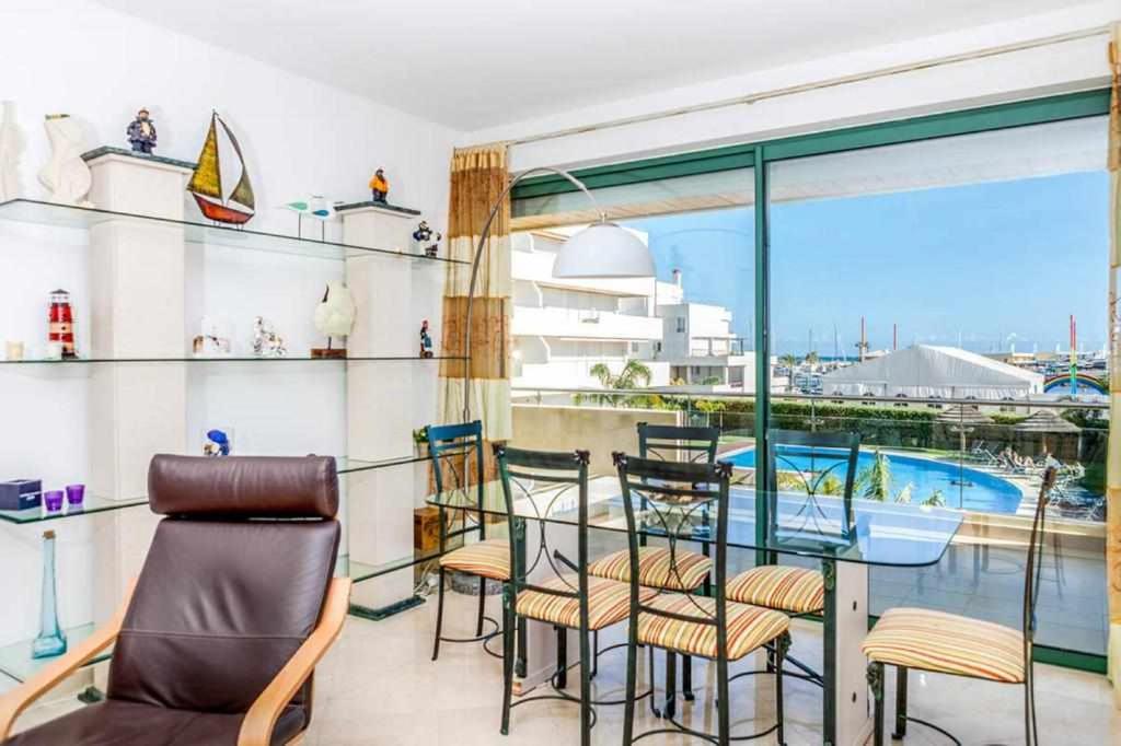uma varanda com cadeiras, uma mesa e uma piscina em Sublime Vilamoura Aquamar 106 by JG Apartments em Vilamoura