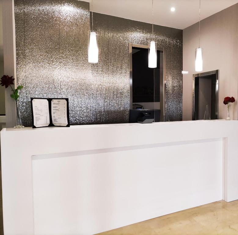 a white counter in a room with a silver wall at Hotel Ciudad de Navalcarnero in Navalcarnero