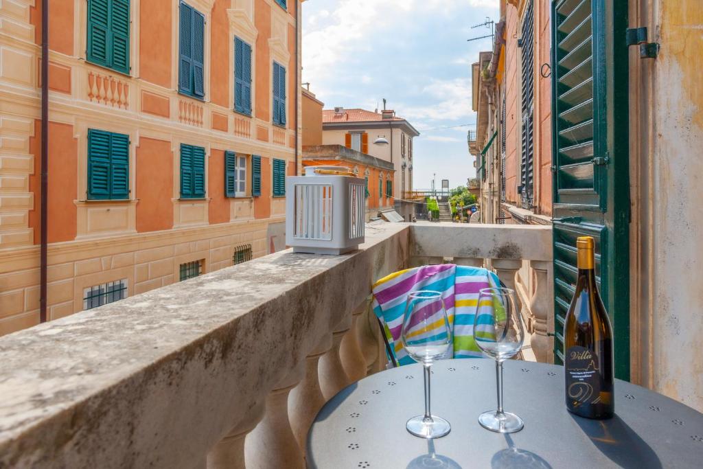 un tavolo con 2 bicchieri da vino sul balcone di Leone I and Leone II Apartments a Levanto