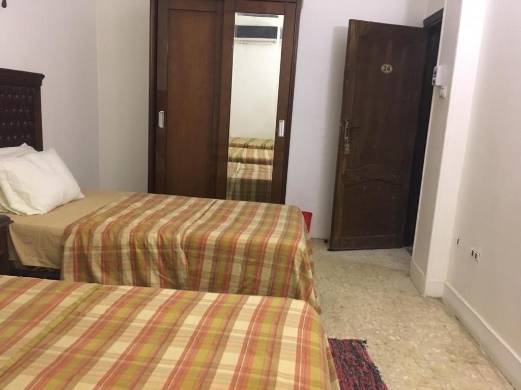 Habitación de hotel con 2 camas y espejo en Thomas' NEW en El Cairo
