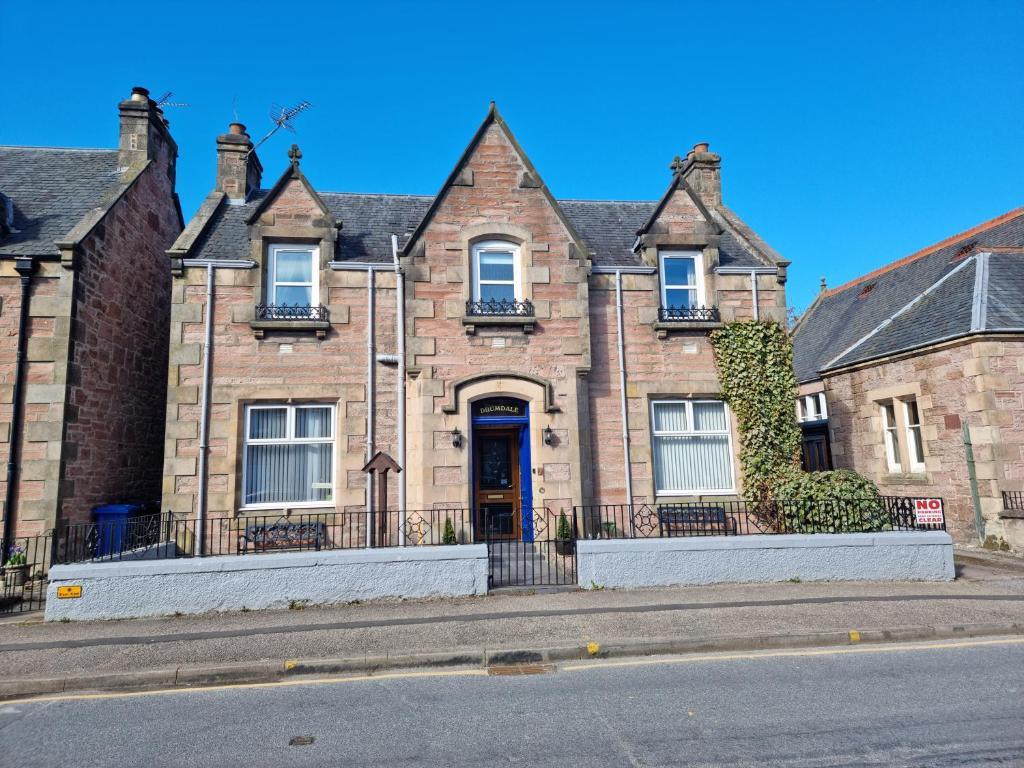 a large brick house with a front door on a street at Drumdale Bed and Breakfast in Inverness