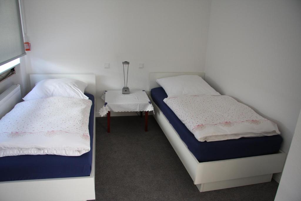 2 camas en una habitación con mesa auxiliar en C+U Ferienwohnungen en Harthausen
