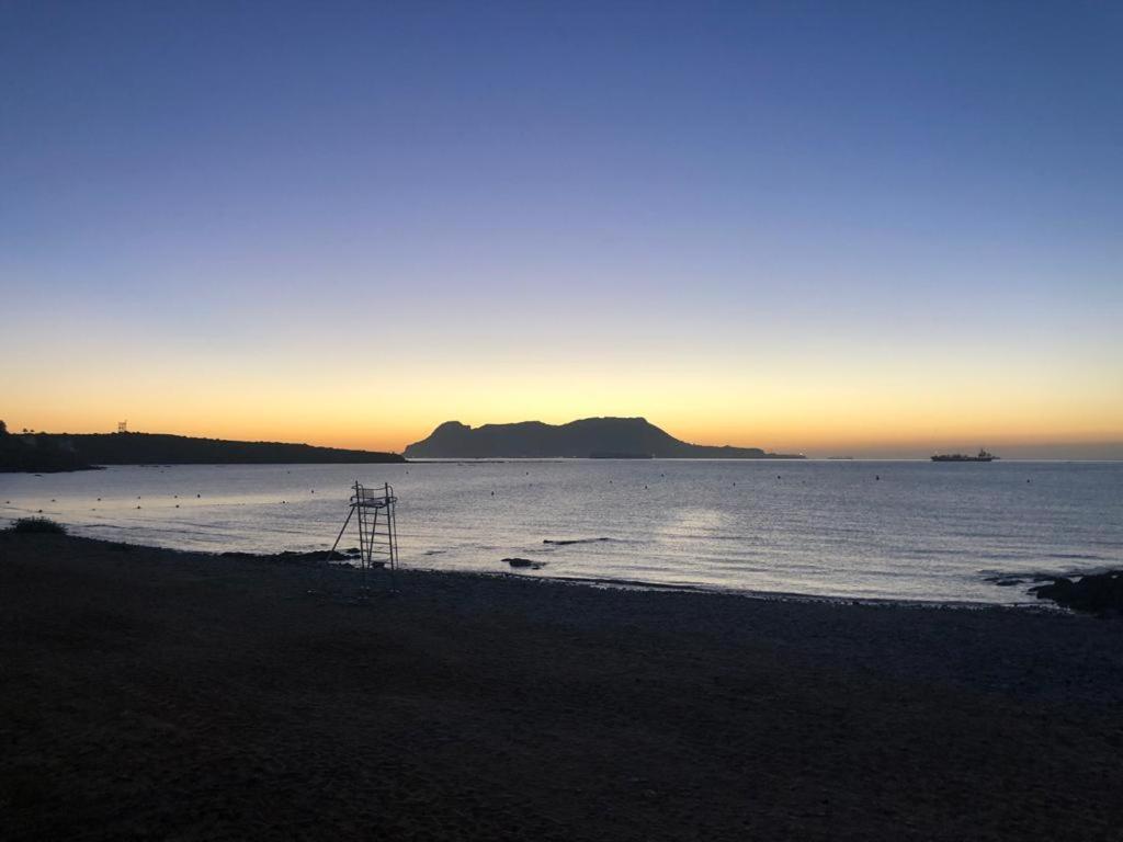 - une vue sur l'océan au coucher du soleil avec une plage dans l'établissement Precioso apartamento 1ª linea de playa Getares, à Algésiras