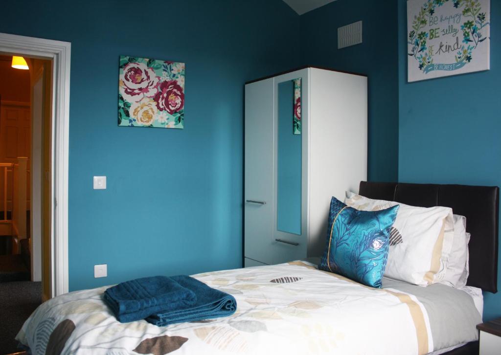 1 dormitorio azul con 1 cama con pared azul en Sidings Holt - whole house sleeps up to 7 en Crewe