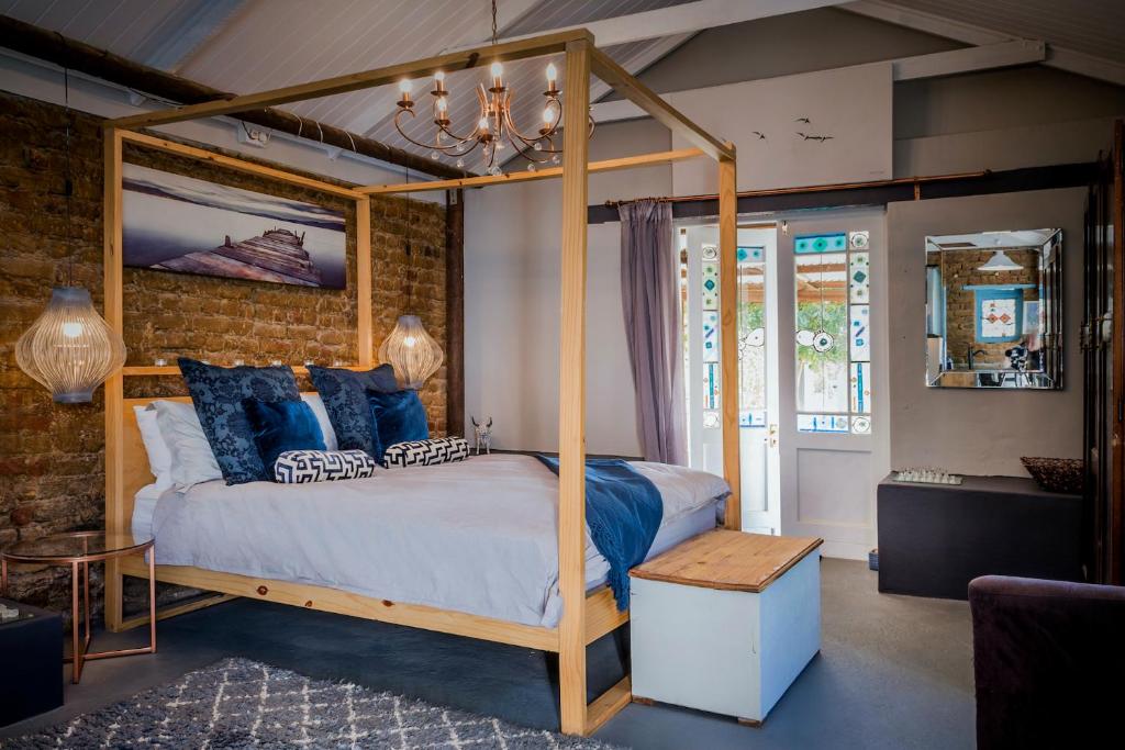 a bedroom with a canopy bed and a brick wall at 1 Queen Vic in Darling