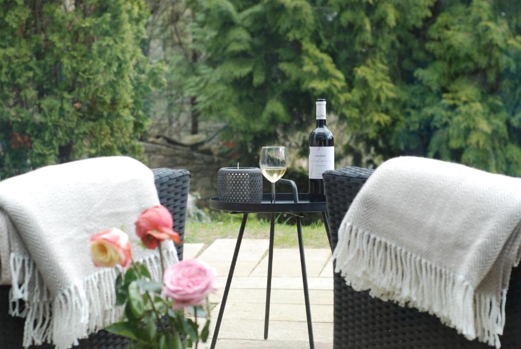 uma mesa com um copo de vinho e duas cadeiras em Crystal Studio em Kutná Hora