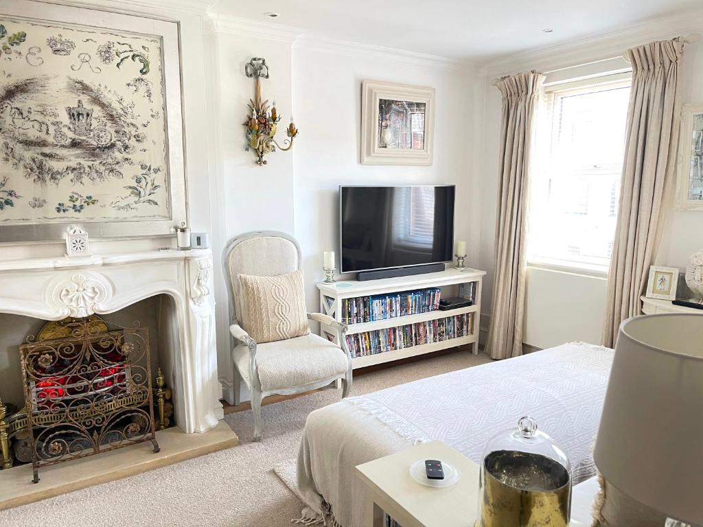 een woonkamer met een open haard en een televisie bij Beautiful Lymington New Forest Getaway in Lymington