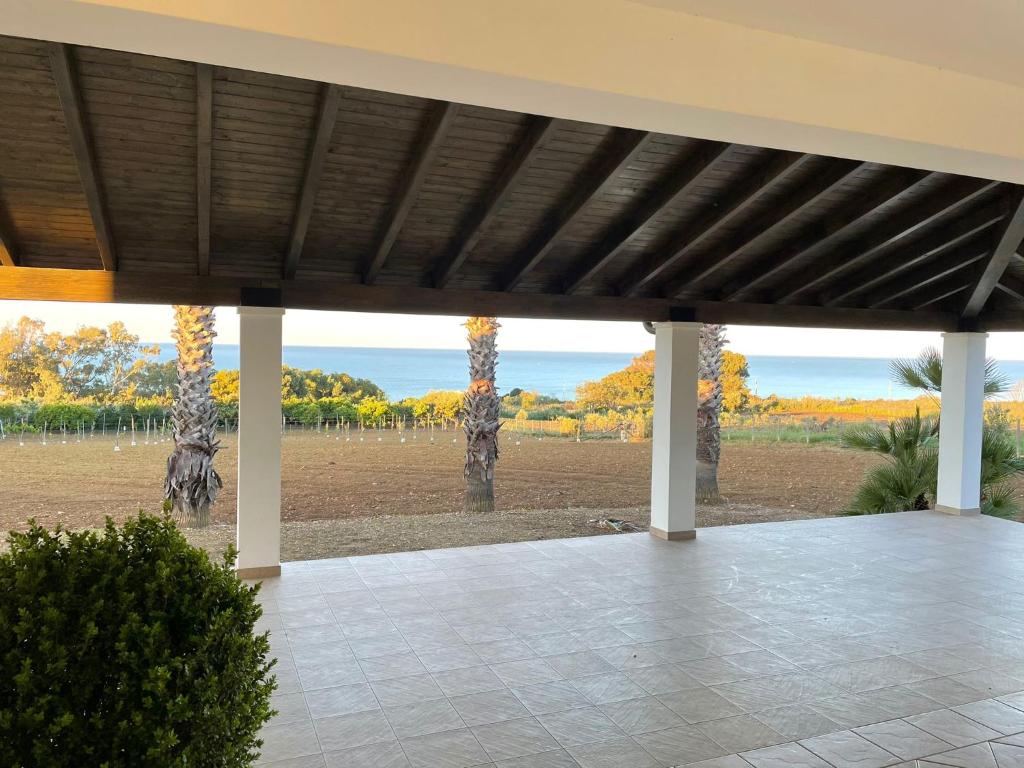 a patio with a view of a field and trees at Villa Mancosta in Marinella di Selinunte