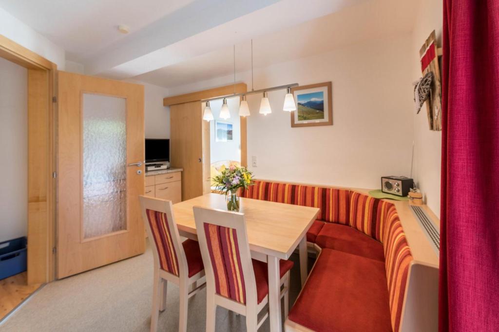 uma cozinha e sala de jantar com mesa e cadeiras em Ferienwohnung Valentina em Schwendau